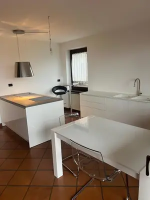 a kitchen with a white table and a sink at Villa Claudio in Cavareno