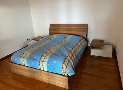 a bed with a blue comforter in a bedroom at Villa Claudio in Cavareno