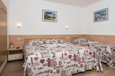 two beds in a hotel room with a bedspread at Garni Ciamorc in Canazei