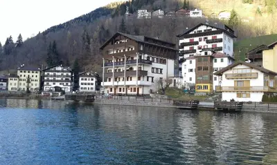 a group of buildings next to a body of water at Appartamento Italia in Alleghe