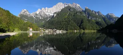 a reflection of mountains in a body of water at Appartamento Italia in Alleghe