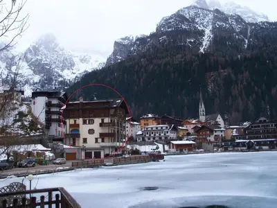 a town with a frozen lake in front of a mountain at Appartamento Italia in Alleghe