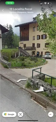 a building on the side of a road next to a street at Sweet Home Cortina in Cortina dʼAmpezzo