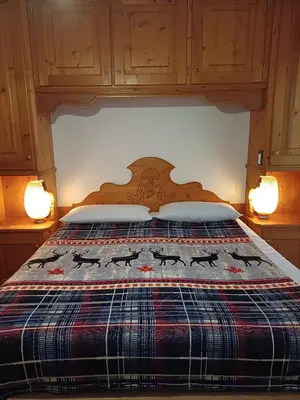 a bedroom with a bed with a quilt on it at Sweet Home Cortina in Cortina dʼAmpezzo