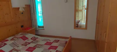 a bedroom with a bed and a mirror on the wall at Appartamenti Ciasa Murin in San Cassiano