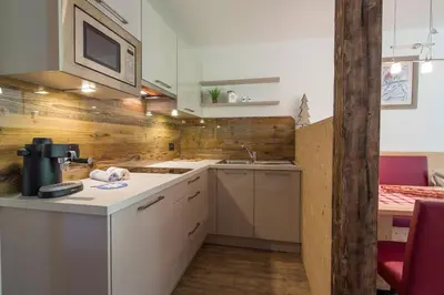 a kitchen with a sink and a microwave above a counter at Appartamenti Ciasa Murin in San Cassiano