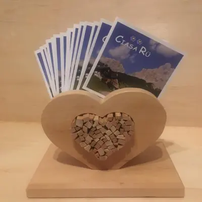 a wooden heart on a stand with a book at Ciasa Rü in San Cassiano