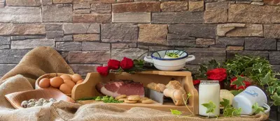 a table with a box of food and eggs and flowers at Ciasa Rü in San Cassiano