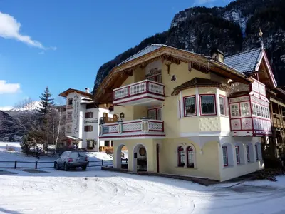 a building with a car parked in front of it at Appartamenti Majon Sotroi in Campitello di Fassa