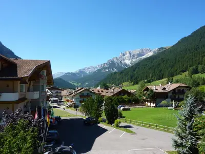 a view of a village with mountains in the background at Appartamenti Majon Sotroi in Campitello di Fassa