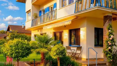 a house with a balcony and a table and chairs at Rauchhof Apartments in Ora/Auer