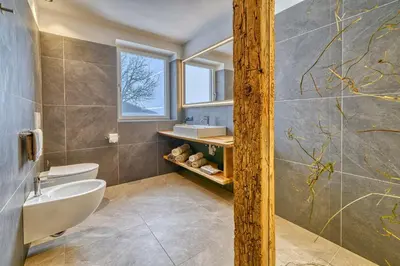 a bathroom with a shower with gold writing on the wall at Hinterrainerhof - Nature Apartments in Avelengo