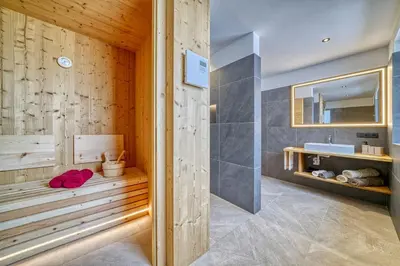 a bedroom with a tub and a bed and a window at Hinterrainerhof - Nature Apartments in Avelengo