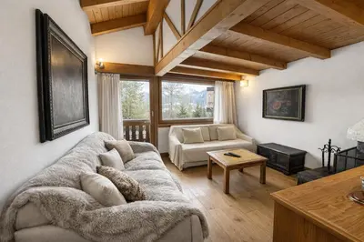 a living room with a couch and a table at Alverà Apartment in Cortina dʼAmpezzo