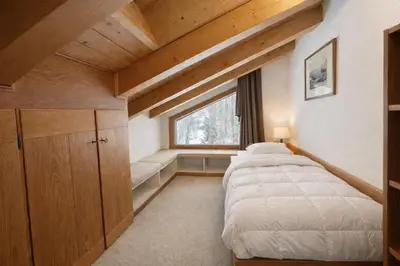 a bedroom with two beds and a window at Alverà Apartment in Cortina dʼAmpezzo