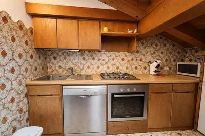 a small kitchen with a sink and a stove at Alverà Apartment in Cortina dʼAmpezzo