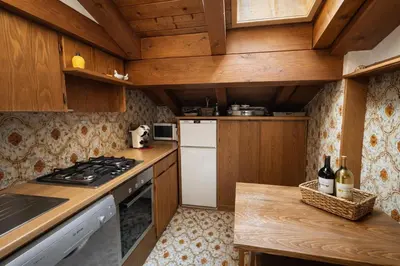 a kitchen with wooden cabinets and a stove top oven at Alverà Apartment in Cortina dʼAmpezzo