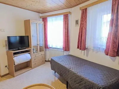 a bedroom with a bed and a flat screen tv at Apartment Cesa Cristina by Interhome in Campitello