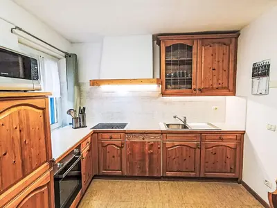 a kitchen with wooden cabinets and a sink at Apartment Cesa Cristina by Interhome in Campitello