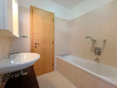 a bathroom with a white tub and a sink at Apartment Casa Dalpi by Interhome in Predazzo
