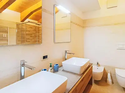 a bathroom with two sinks and a toilet at Apartment Valeria by Interhome in Pera
