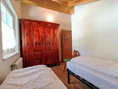a bedroom with two beds and a wooden cabinet at Apartment Cesa sot Larsec by Interhome in Campestrin
