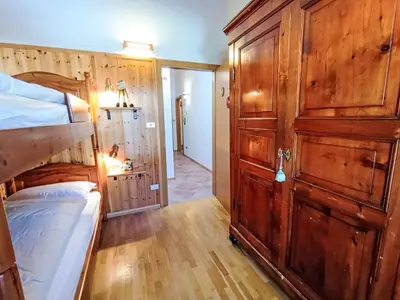 a bedroom with a bunk bed and a wooden wall at Apartment Cesa sot Larsec by Interhome in Campestrin