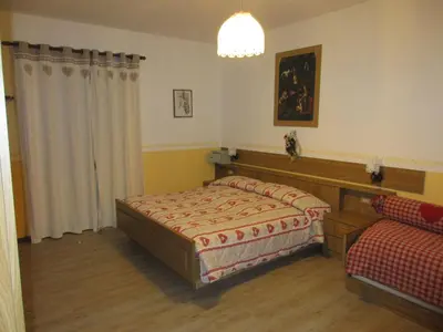 a bedroom with a bed and a couch in it at Garnì Defrancesco in Campitello di Fassa
