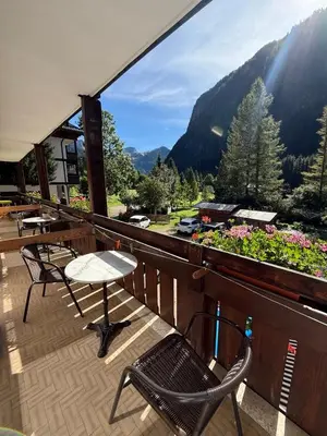 a balcony with chairs and a table and flowers at Garnì Defrancesco in Campitello di Fassa