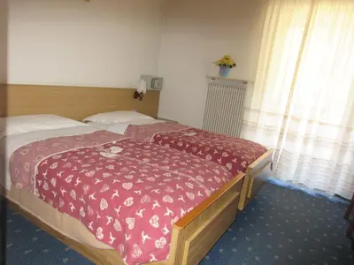 a bedroom with a bed with a red blanket on it at Garnì Defrancesco in Campitello di Fassa