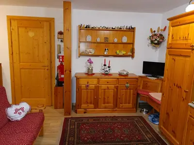 a living room with wooden cabinets and a red couch at Trampolini House in Predazzo