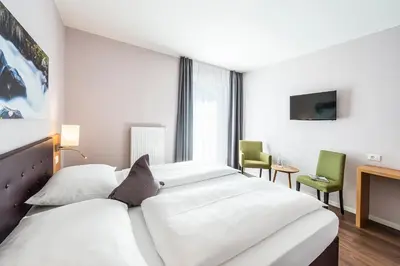 a hotel room with two beds and a tv at Hotel Jardis in Lana