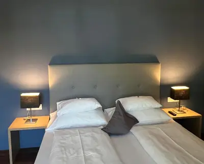 a bedroom with two beds and two lamps on tables at Hotel Jardis in Lana