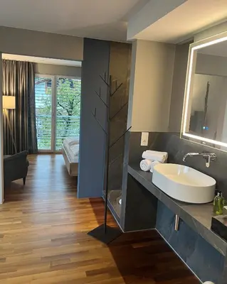 a bathroom with a sink and a large mirror at Hotel Jardis in Lana