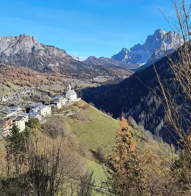 a small village on a hill with mountains in the background at Balcone sul Civetta in Colle Santa Lucia