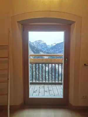 a door to a balcony with a view of mountains at Balcone sul Civetta in Colle Santa Lucia