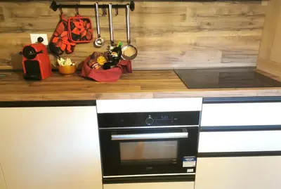 a kitchen counter with a black and white stove top oven at Balcone sul Civetta in Colle Santa Lucia
