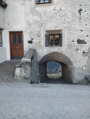 a stone building with an arch in front of a door at Balcone sul Civetta in Colle Santa Lucia