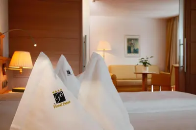 a bedroom with two beds and a living room at Hotel Peter in Petersberg