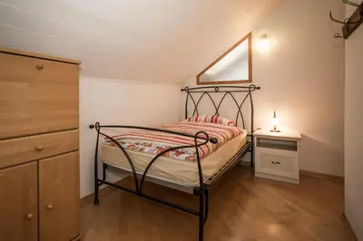 a small bedroom with a bed and a dresser at Villa Sissi in Laives