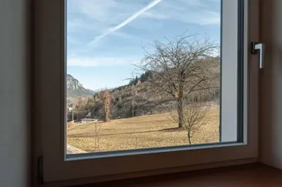 a window with a view of a field and mountains at Duplex Cermis in Cavalese