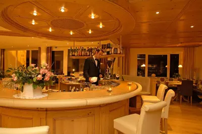 a man standing at a bar in a restaurant at Hotel Grones in Ortisei