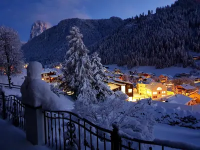 a village in the snow at night at Hotel Grones in Ortisei