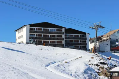 a building on top of a snow covered hill at Berghaus-Olymp Kronplatz in Brunico