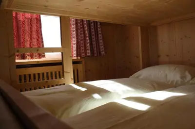 a bedroom with a white bed and a window at Berghaus-Olymp Kronplatz in Brunico