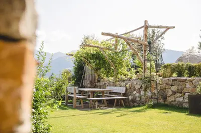 a restaurant with wooden tables and chairs at feldthurnerhof vinum-natur-relax in Feldthurns