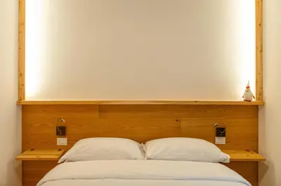 a couch in a living room with a wooden wall at DE Earth - Appartamento con Sauna in Caprile