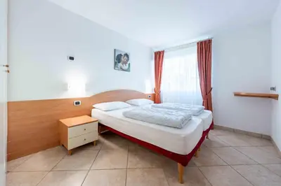 a small bedroom with a bed and a night stand at Cesa Primula in Canazei