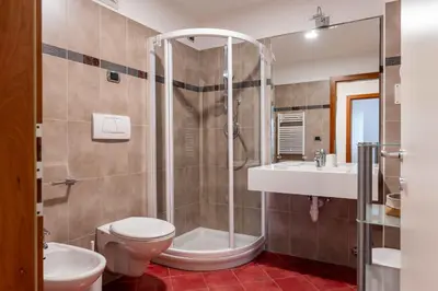 a bathroom with a shower and a toilet and a sink at Cesa Primula in Canazei