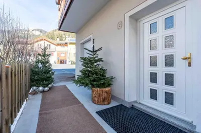 two christmas trees are sitting in front of a door at Cesa Primula in Canazei